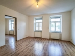 Wohnzimmer - Attraktive 3‑Zimmer-​Wohnung mit Gemeinschaftsgarten und Parkplatz
